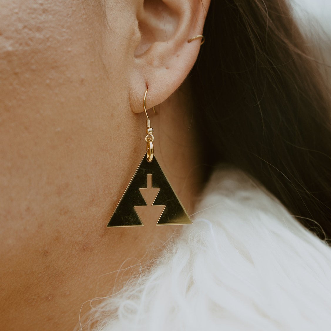 close up of woman wearing Brass triangle with southwest geometric shapes from copper canoe woman