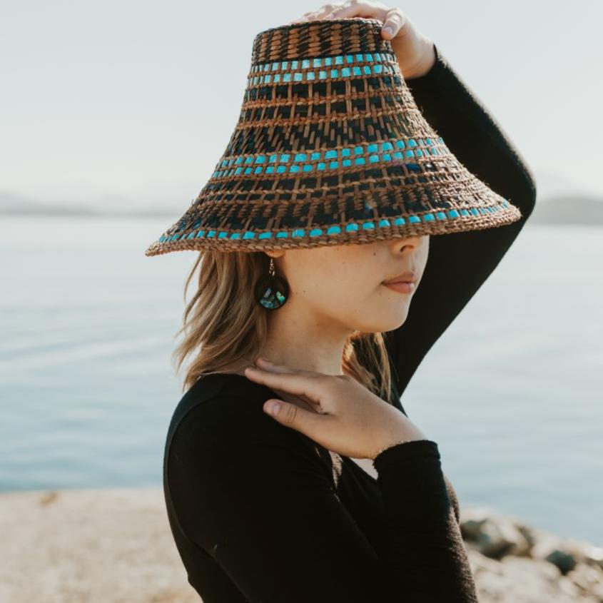 young woman wearing black acrylic earring with mountain cut out and abalone inlay from copper canoe woman