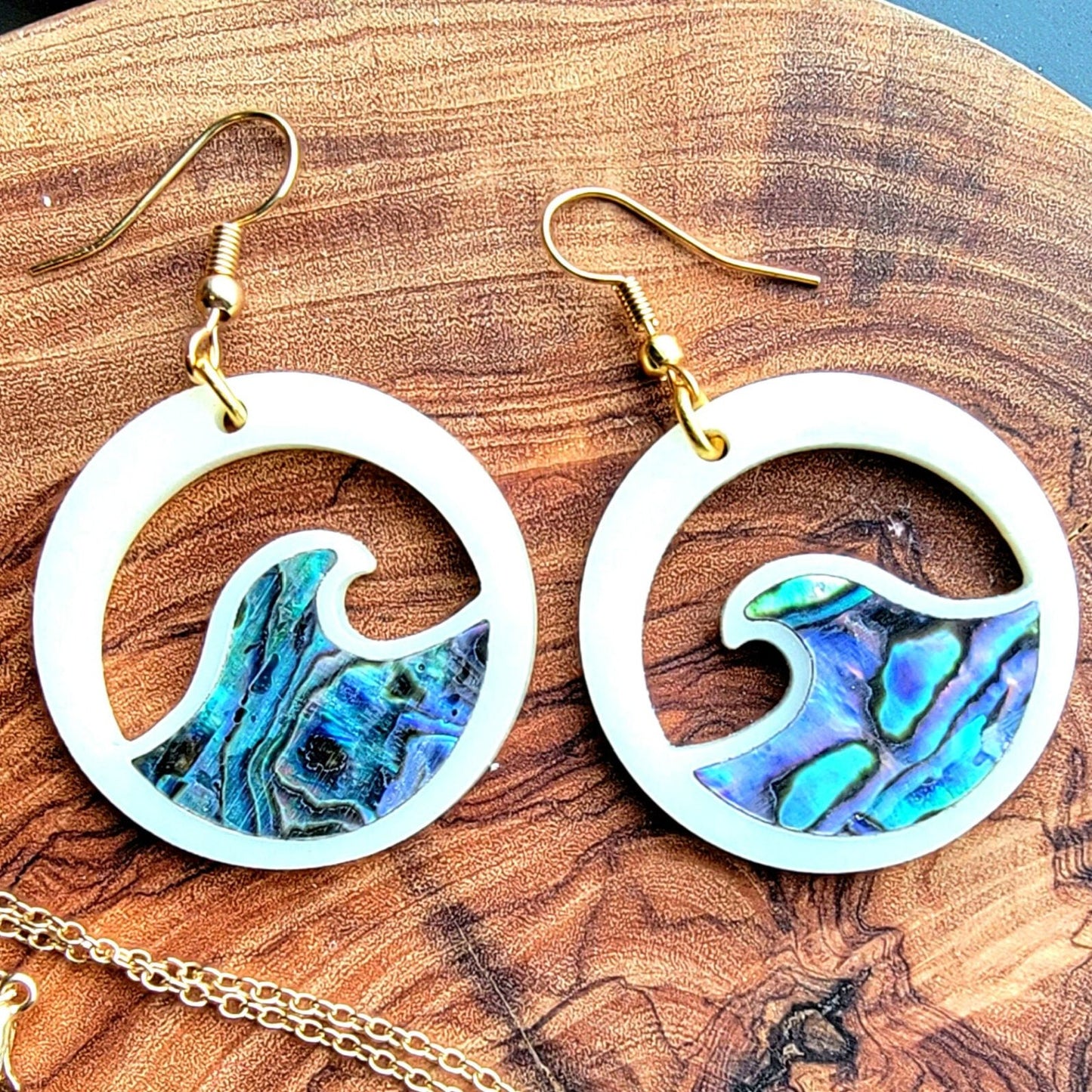 ivory acrylic earring with wave cut out and abalone inlay from copper canoe woman