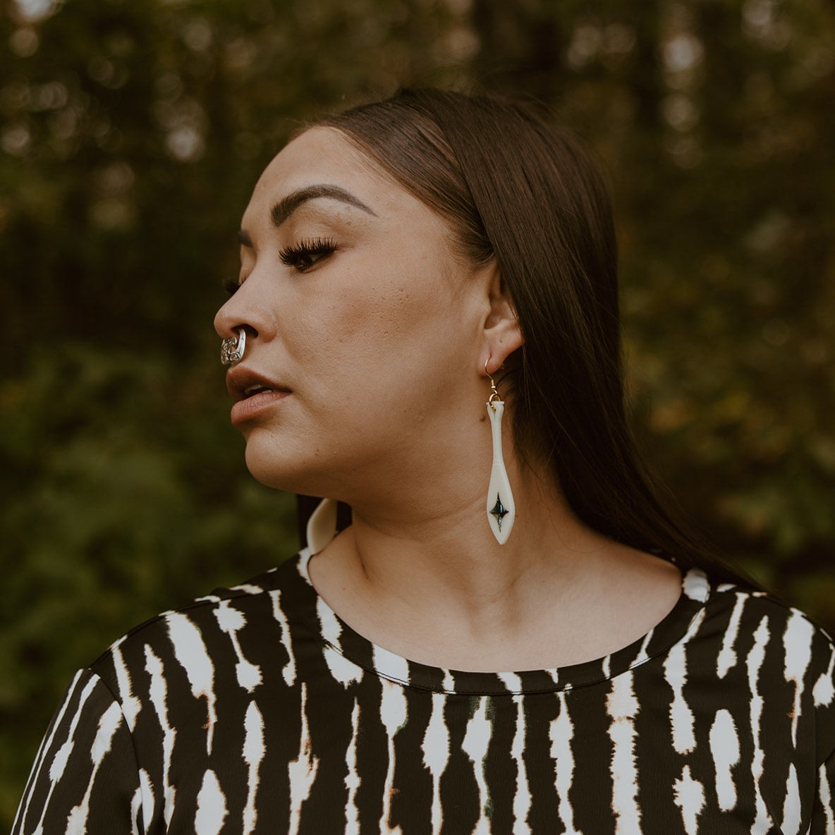 woman wearing Ivory acrylic paddle earring with star abalone inlay from copper canoe woman