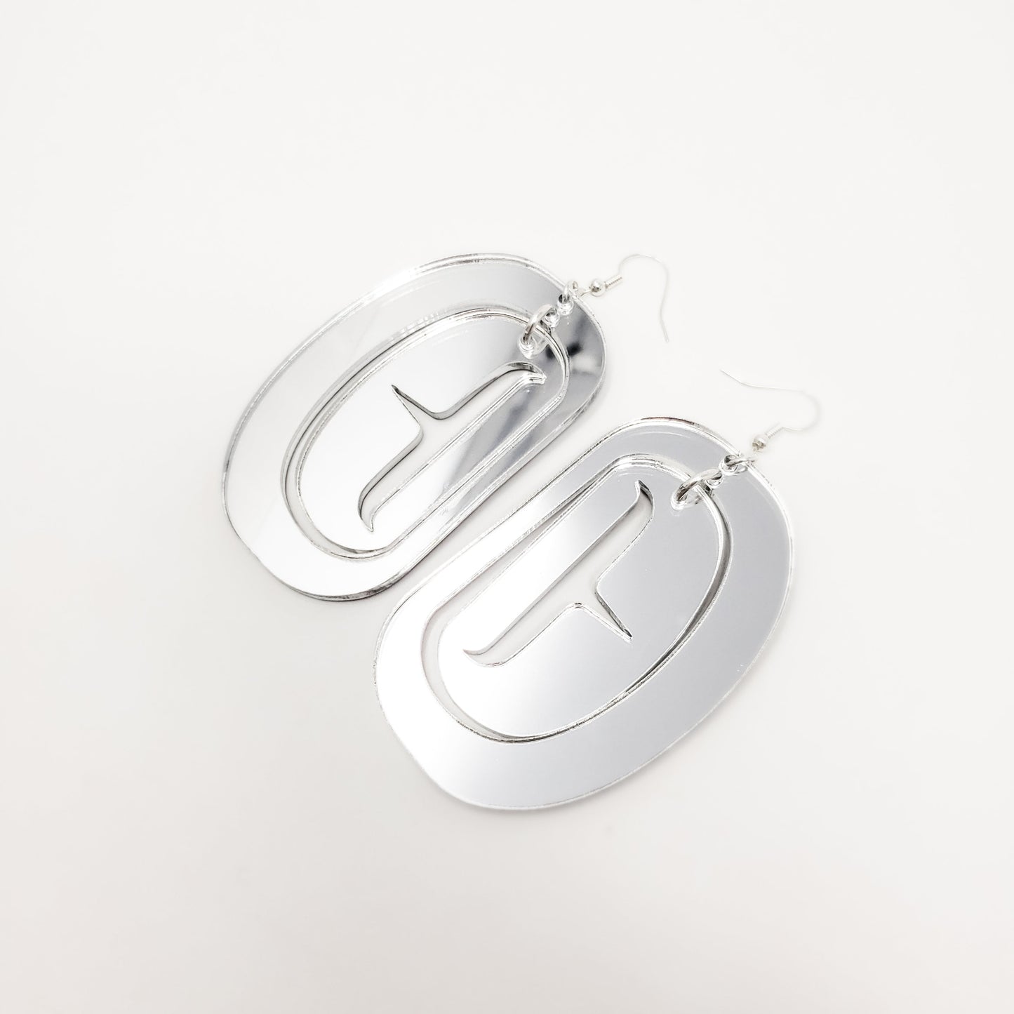 Silver mirror acrylic large ovoid earrings with trigon cutout from Copper Canoe Woman.