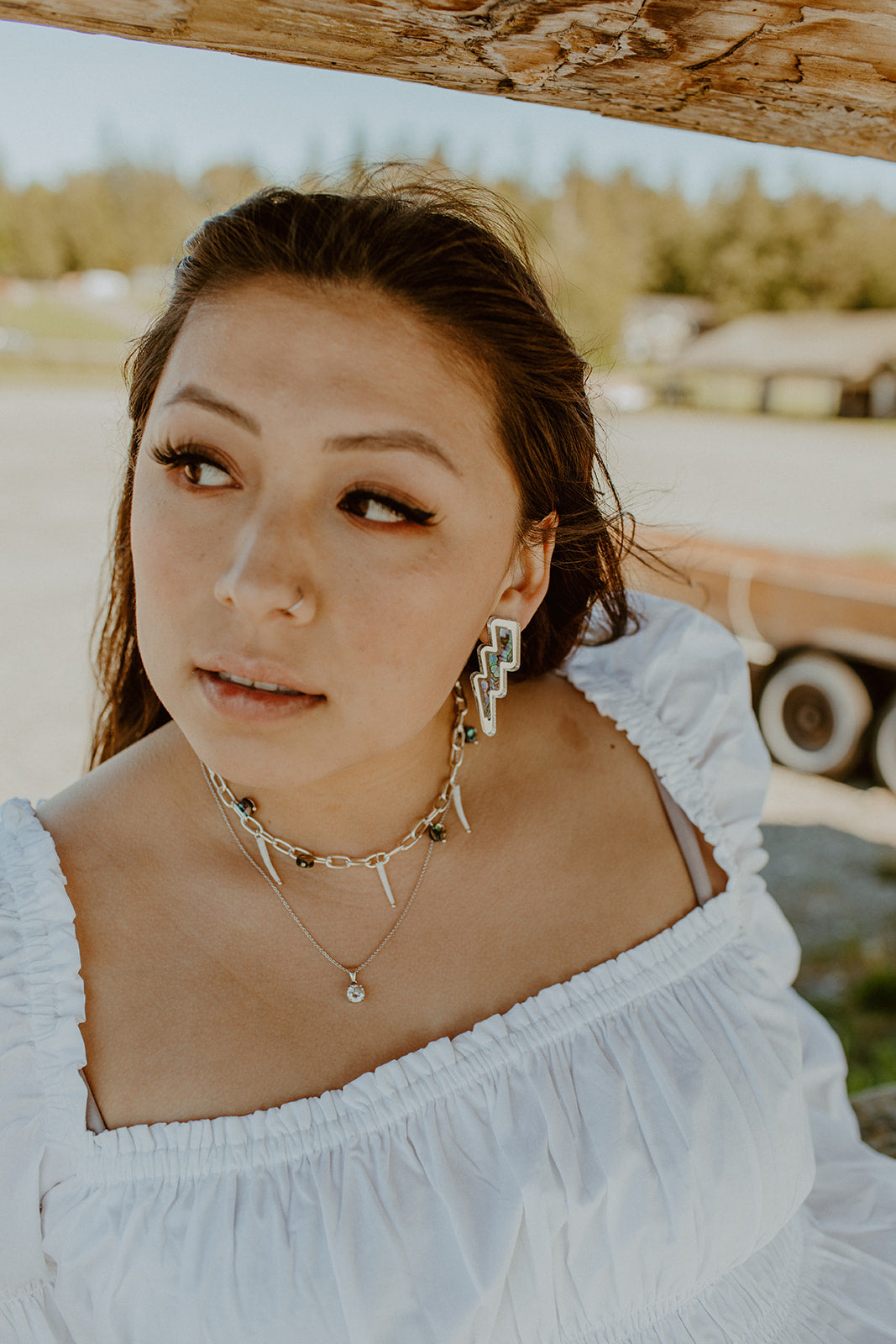 Model wearing silver mirror lightning bolt earrings from Copper Canoe Woman.