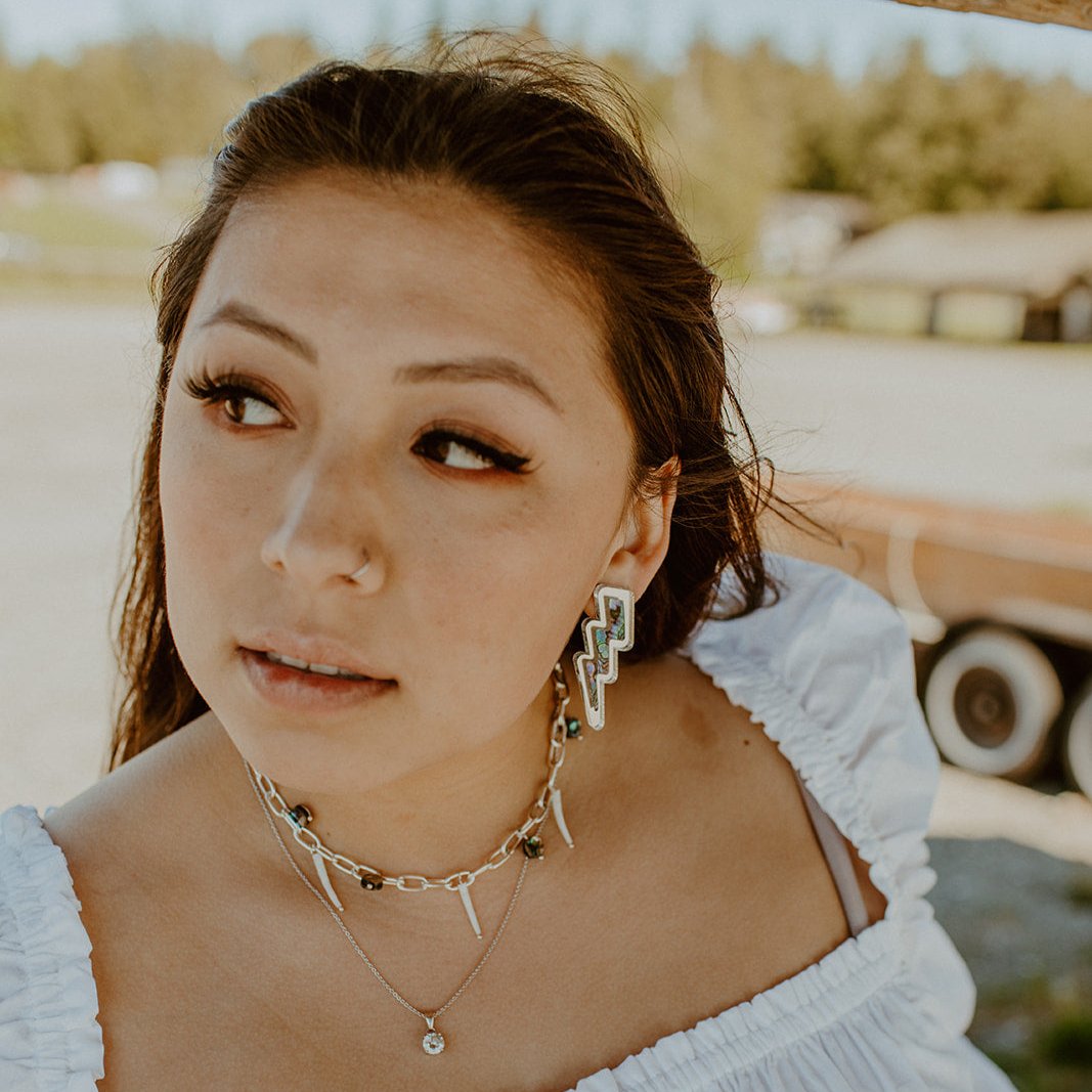 Model wearing silver mirror lightning bolt earrings from Copper Canoe Woman.