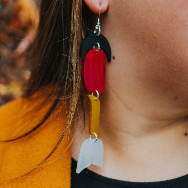 woman wearing abstract formline art in color sequence of black, red, yellow, white from copper canoe woman.