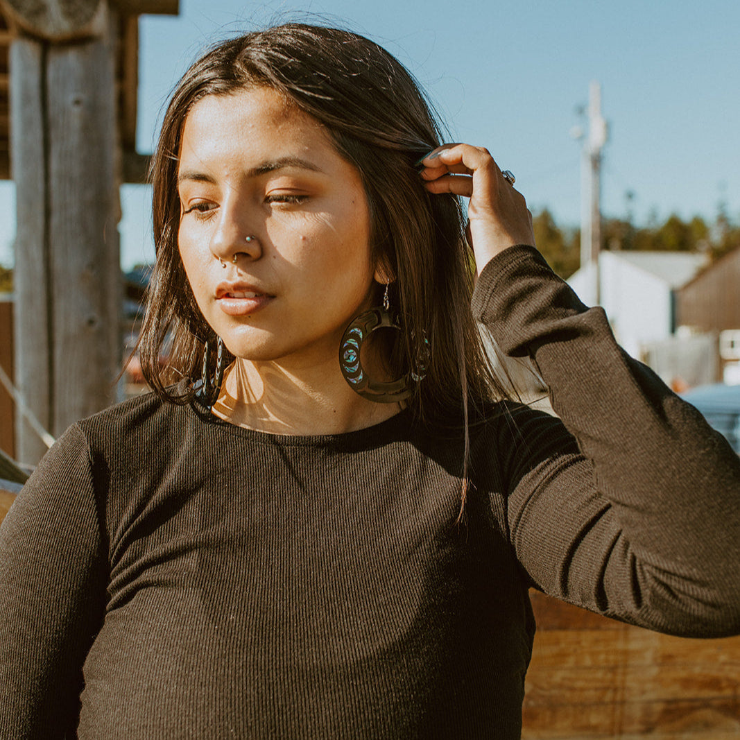 Model wearing black Nala Hoop earrings from Copper Canoe Woman.