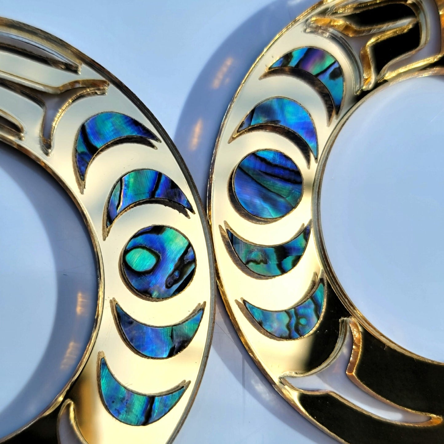 Closeup of a gold mirror acrylic Nala Hoop earring.