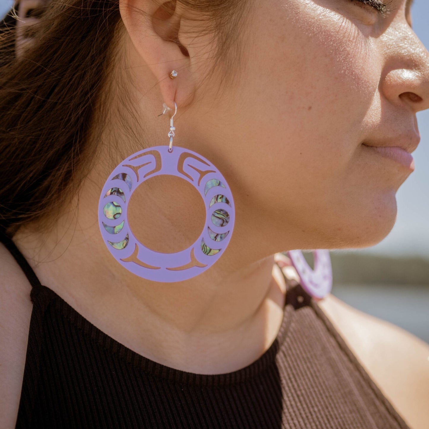 Closeup of a model wearing the lavender Nala Hoop earring from Copper Canoe Woman.