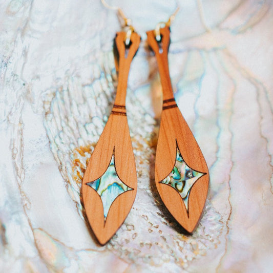 cedar paddle earring with star abalone inlay from copper canoe woman