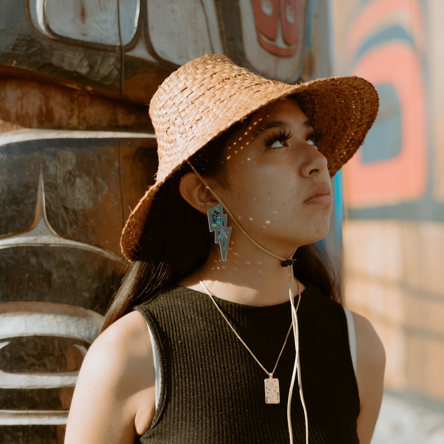 Young girl wearing silver acrylic lightning bolt earring with abalone inlay from Copper Canoe Woman