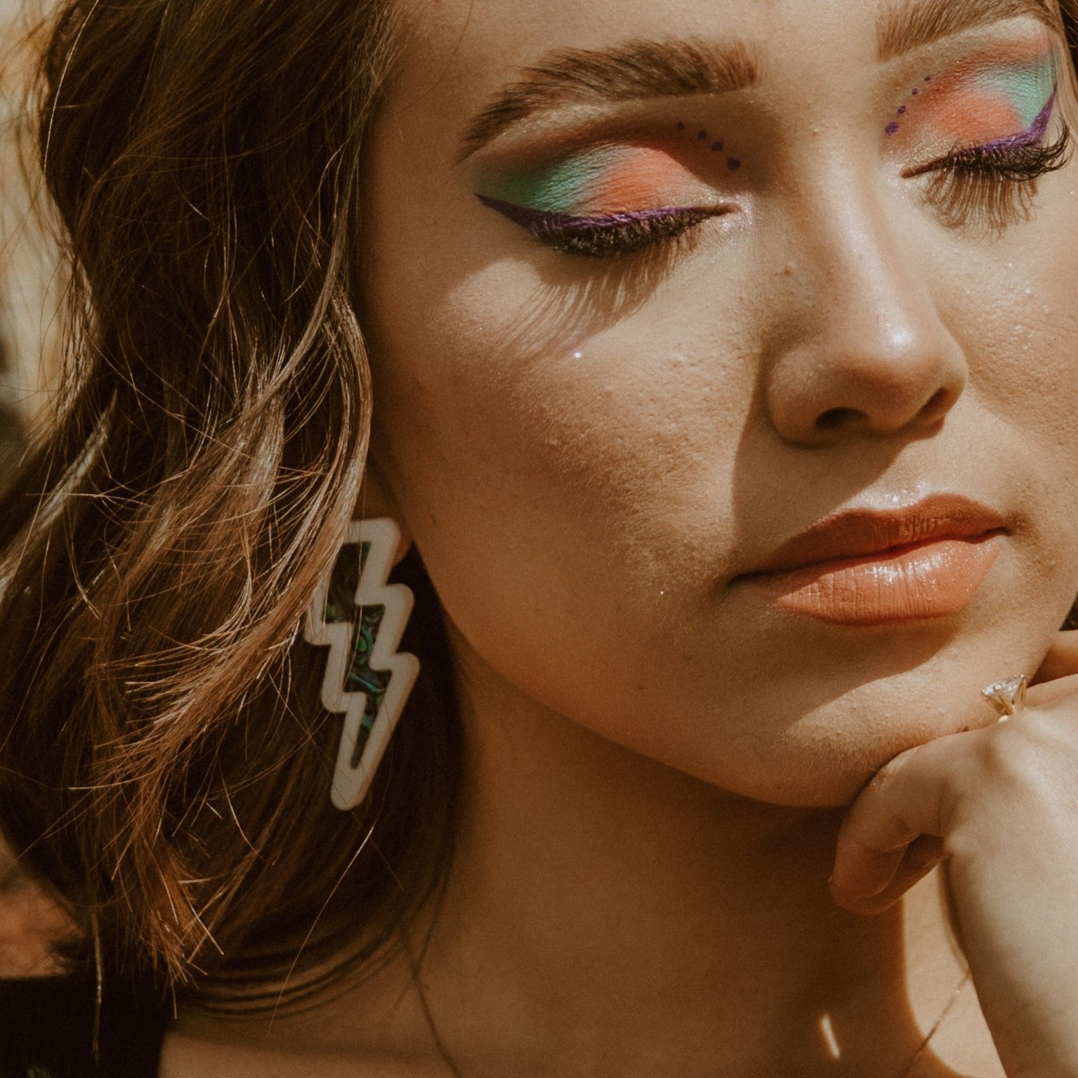 Model wearing white acrylic lightning bolt earrings from Copper Canoe Woman.