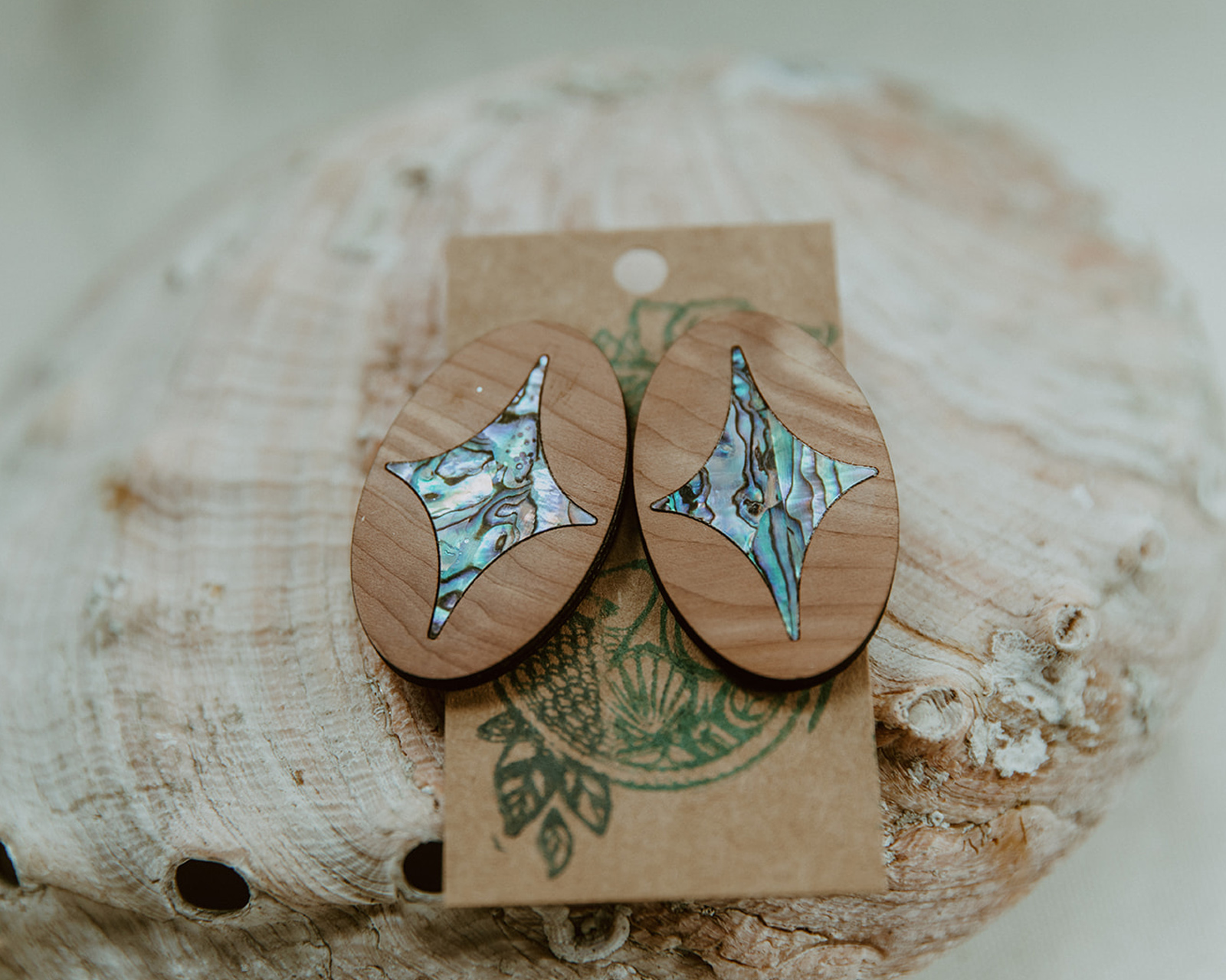 Ovular cedar post earrings with an abalone four-pointed star shape