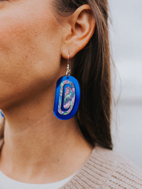 Cobalt mirror ovoid earring with abalone inlay worn by model.