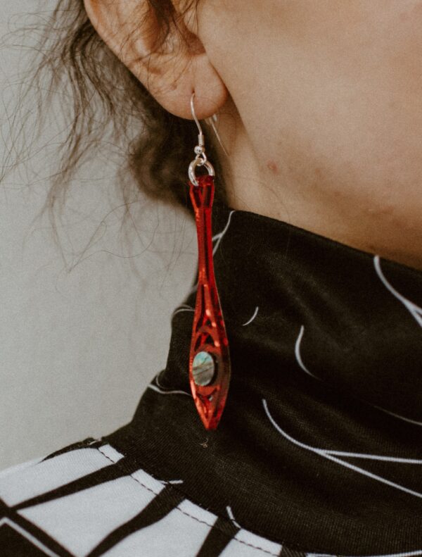 Paddle shaped earring in red mirror acrylic worn by model.