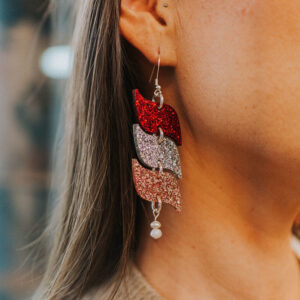 Model wearing 'Drop of Love' 3-tier s-shape acrylic earring in three glitter colors.