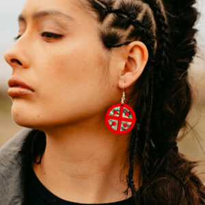 Closeup of model wearing the Protector Shield earring in red mirror acrylic.